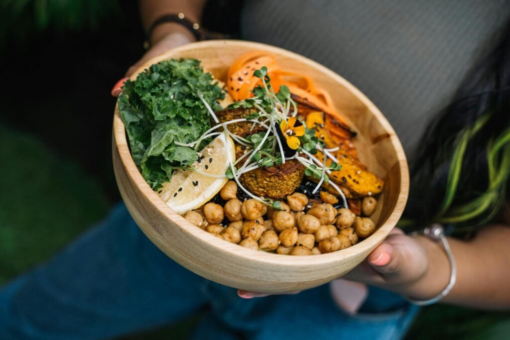 Healthy vegan bowl with chickpeas, kale, carrots, and lemon served fresh. ins and outs 2025, holistic health.